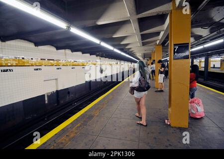 Passagers attendant sur la plate-forme de la gare 7th Avenue à Manhattan, New York. Banque D'Images