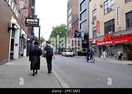 Un juif orthodoxe socialisant avec un homme laïque sur la W 3rd Street à Manhattan, New York City, USA. Banque D'Images