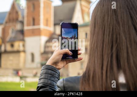 Une femme voyageur dans des lieux historiques regarde autour de la cour d'un monument et tourne de courtes vidéos au téléphone. Photos touristiques lieu historique le jour ensoleillé. Femme méconnaissable Tourisme et blogging partage en ligne pour le public Voyage ensemble enregistrement vidéo sur téléphone mobile Banque D'Images