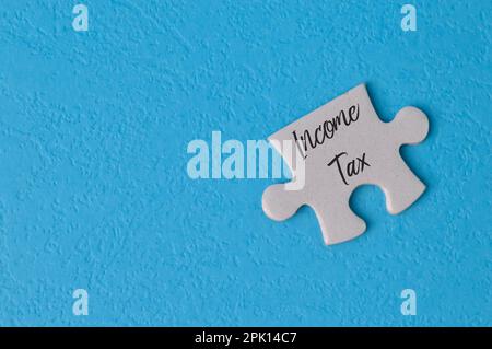 Puzzle écrit avec texte IMPÔT SUR LE REVENU isolé sur un fond bleu Banque D'Images