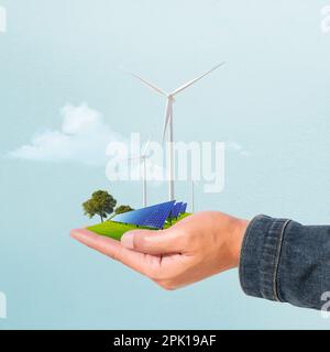 Turbine éolienne et panneaux solaires dans la main mâle. nouvelle génération d'énergie propre et écologique. Banque D'Images