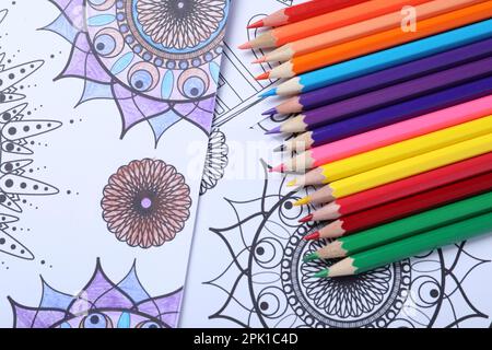 Crayons sur les pages de coloriage antistress, vue de dessus Banque D'Images