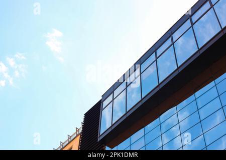 Vue à angle bas du bâtiment moderne avec fenêtres teintées sur ciel bleu Banque D'Images