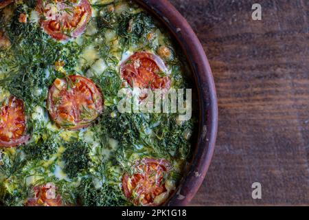 Bol en céramique avec frittata de légumes, simple nourriture végétarienne. Frittata avec oeuf, tomate, poivre, oignon, brocoli vert et fromage sur table en bois, clo Banque D'Images