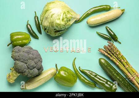 Mot LÉGUME et cadre fait de différents légumes frais sur fond bleu Banque D'Images