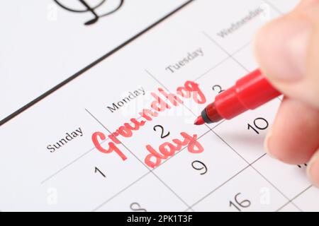 Femme marquant la date du jour de la marmotte dans le calendrier, clôture Banque D'Images