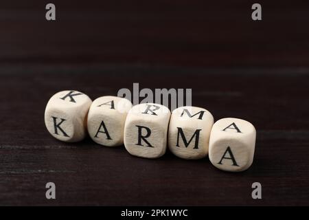 Mot Karma fait de cubes avec des lettres sur une table en bois Banque D'Images