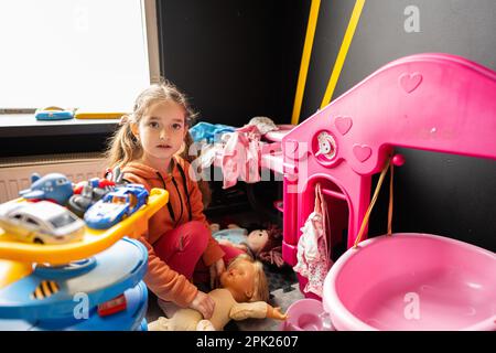 Jeune fille dans un centre de garde de jour jouant avec des jouets de poupées. Banque D'Images