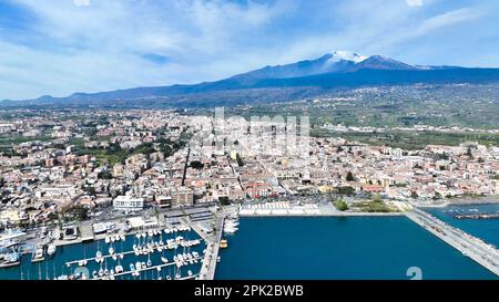 Riposto destination d'été - vue aérienne d'en haut sur le port avec des bateaux pendant la journée ensoleillée avec le volcan Etna en arrière-plan avec la mer Banque D'Images