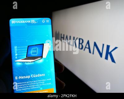 Personne tenant un téléphone portable avec le site de la société Turkiye Halk Bankasi A.S. (Halkbank) à l'écran avec logo. Concentrez-vous sur le centre de l'écran du téléphone. Banque D'Images