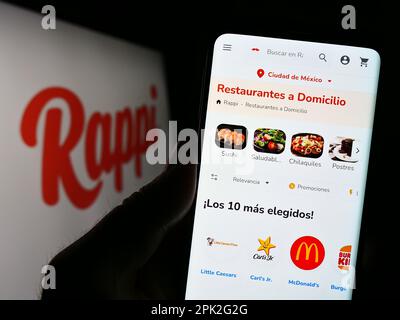 Personne tenant un smartphone avec la page Web de la compagnie colombienne de livraison d'aliments Rappi Inc. À l'écran avec le logo. Concentrez-vous sur le centre de l'écran du téléphone. Banque D'Images