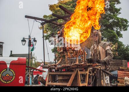 Flames est originaire de la bouche d'un dragon qui respire le feu lors du festival international de marionnettes de Skipton. L'opérateur est sur des pilotis, Banque D'Images