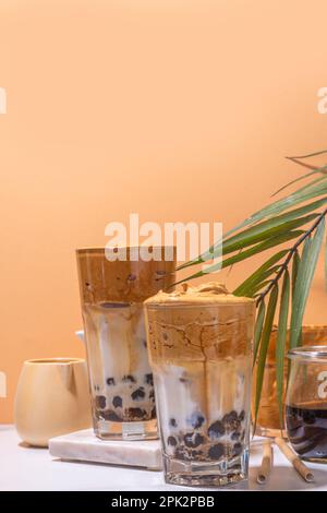 Café de la Dalgona de Boba. Boisson tendance du matin latte asiatique avec café instantané fouetté et boules de perles de tapioca, cocktail thaïlandais d'été avec bulle de verre ensoleillé Banque D'Images