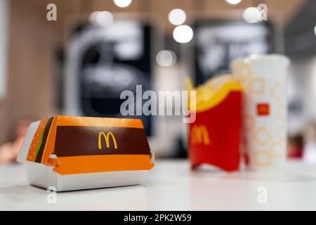 Big Mac Box avec logo McDonald's, frites et boisson non alcoolisée sur table au restaurant McDonald's. Mise au point sélective. Minsk, Bélarus, 2023 Banque D'Images