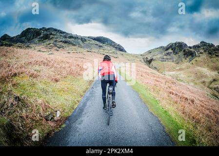 Cycliste de route de sexe masculin en haut du col de Hardnout, Eskdale, Cumbria, Royaume-Uni. Banque D'Images