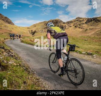 Un cycliste de la route de sexe masculin escalade du col HardKnott dans le défi Fred Whitton, district de English Lake. Banque D'Images