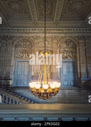 Détails architecturaux d'un escalier, hall orné et lustre d'époque brillant pend du plafond, Château de Versailles, France Banque D'Images