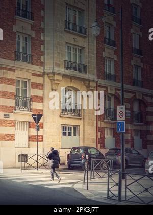 Scène en plein air avec une personne traversant la rue sur le passage en croix à Asnieres sur Seine, une banlieue parisienne, France Banque D'Images