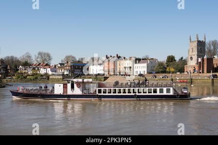 Une promenade en bateau de plaisance sur la Tamise en face de l'église All Saints Church et de la propriété d'Old Isleworth, Londres, Angleterre, Royaume-Uni Banque D'Images