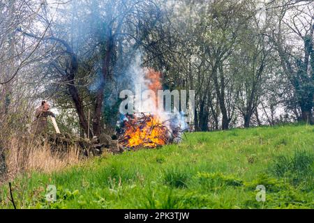 L'homme fait un feu de bois d'ordure et de déchets de jardin à Batheaston, Somerset, Royaume-Uni Banque D'Images