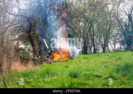 L'homme fait un feu de bois d'ordure et de déchets de jardin à Batheaston, Somerset, Royaume-Uni Banque D'Images