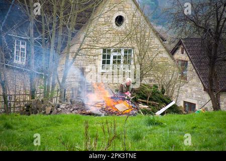 L'homme fait un feu de bois d'ordure et de déchets de jardin à Batheaston, Somerset, Royaume-Uni Banque D'Images