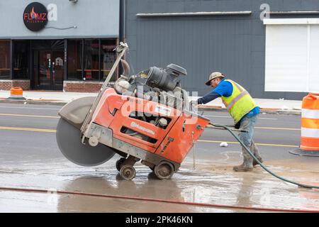 Detroit, Michigan - Un travailleur exploite une scie à béton à l'état de marche dans le cadre d'un projet visant à créer des pistes cyclables protégées, des trottoirs plus larges et à planter le tr Banque D'Images