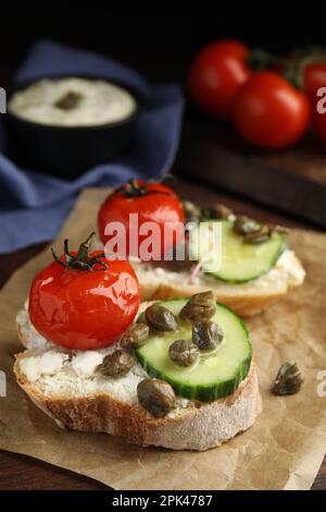 Bruschettas savoureux avec légumes et câpres sur table, gros plan Banque D'Images