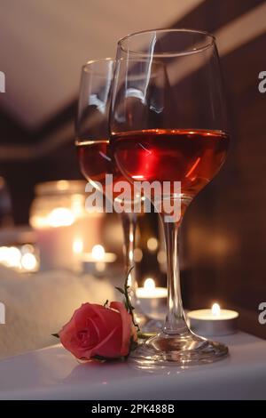 Verres de vin et de rose dans la baignoire de la salle de bains. Ambiance romantique Banque D'Images