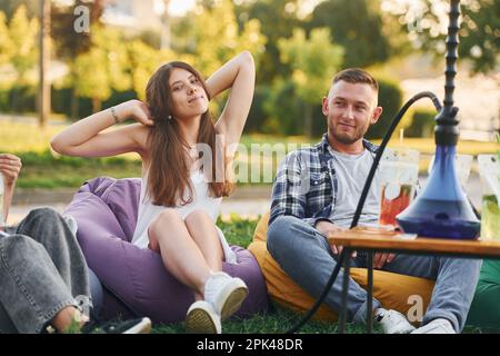 Couple heureux. Un groupe de jeunes ont une fête dans le parc pendant la journée d'été Banque D'Images