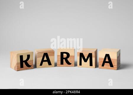 Mot Karma fait de cubes avec des lettres sur fond clair Banque D'Images