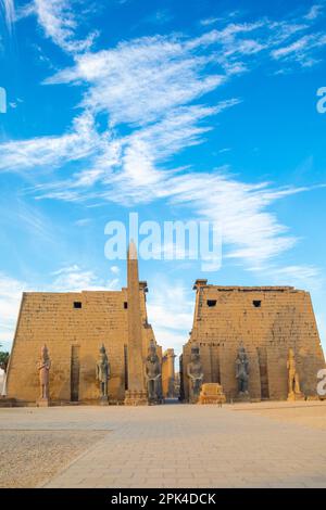Le pylône de Ramsès avec l'Obélisque de l'est et les deux Colosssi du Roi assis sur son trône, Temple de Louxor, Louxor, Egypte, Afrique du Nord-est Banque D'Images