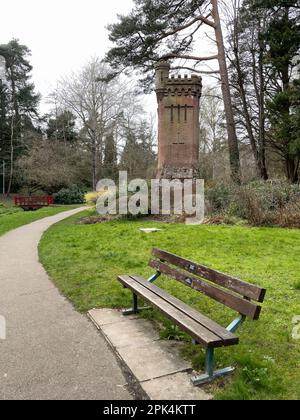 Upper Gardens, Bournemouth, Royaume-Uni - 19 mars 2023 : un banc de parc devant le château d'eau de Bournemouth Gardens dans les jardins classés grade II. Banque D'Images