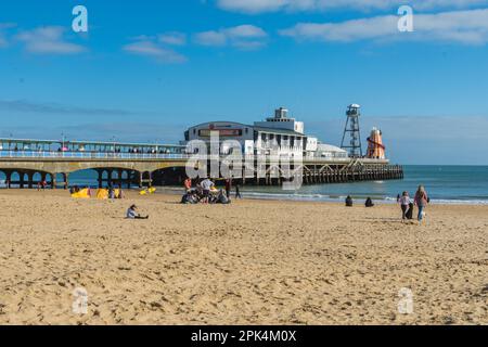 Bournemouth, Royaume-Uni - 2 avril 2023: Les gens sur la plage en face de la jetée. Banque D'Images