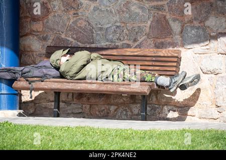Un randonneur qui se repose sur un banc de bord de mer dans un abri en pierre sur la rive ouest au pied du promontoire de la Grande Orme à Llandudno, au nord du pays de Galles. Banque D'Images