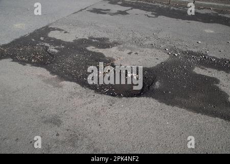 Des nids-de-poule apparaissent sur une route publique du Yorkshire, causés par des fissures de surface, de l'eau et de la circulation exacerbées par la glace et le gel par temps froid Banque D'Images