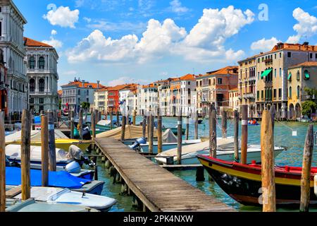 Vue panoramique sur la jetée et le Grand Canal pendant un après-midi ensoleillé avec des bateaux amarrés et à voile et des gondoles dans le centre de Venise, en Italie Banque D'Images