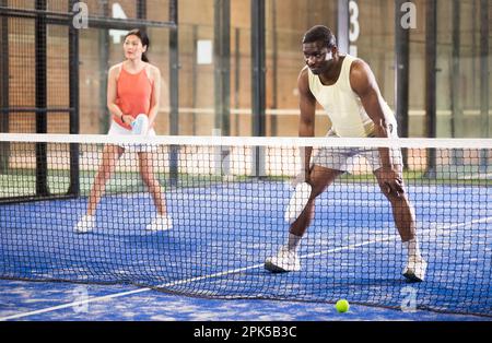 Équipe de padel joueurs homme et femme jouant doubles Banque D'Images