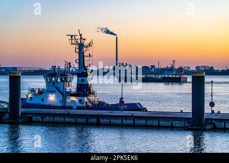 La jetée de remorqueurs, remorqueurs de port en attente de la prochaine affectation, au Nouveau port, coucher de soleil sur l'estuaire de Weser avec à Bremerhaven, Brême, Allemagne Banque D'Images