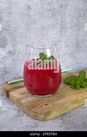 Smoothie à la framboise garni de fruits frais et de menthe. photo verticale Banque D'Images