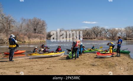 Evans, CO, Etats-Unis - 1 avril 2023: Un groupe de kayakistes se repose sur un banc de sable après le portage du barrage au cours d'un voyage de pagayage au printemps sur la Rive Sud Platte Banque D'Images