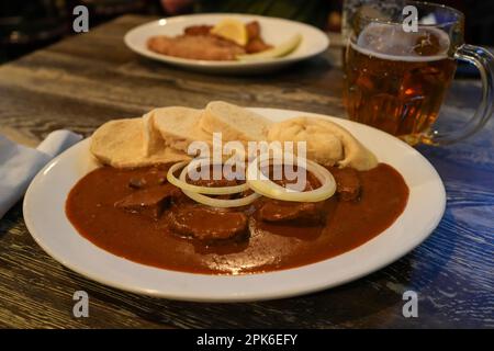 Goulash de bœuf avec boulettes de pain, nappées d'oignon blanc frais. Plaque blanche. Tchèque, européen de Pâques, ukrainien, russe, allemand, Polonais Banque D'Images