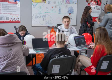 Les enfants s'assoient à une table avec des ordinateurs portables et des tablettes dans une salle de classe. Ouverture officielle du Digital Learning Centre à l'Ecole supérieure des technologies informatiques et de la construction de Lviv, qui a été fondée par l'organisation humanitaire internationale Save the Children avec le soutien du Ministère norvégien des affaires étrangères. L'objectif du Centre d'apprentissage numérique est l'accès sécuritaire à l'enseignement à distance pour les enfants âgés de 6 à 17 ans, l'accès à l'éducation non formelle interactive. Le centre d'apprentissage numérique assure l'accès continu des enfants à l'éducation et à la socialisation de l'enseignement interne Banque D'Images