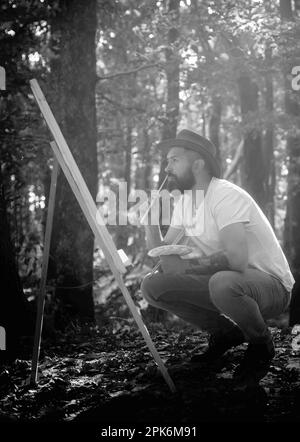 Capturez l'instant. Homme barbu peintre à la recherche de l'inspiration automne nature. Tirer de la vie. Forêt peintre. Concept d'art. Peinture dans la nature Banque D'Images