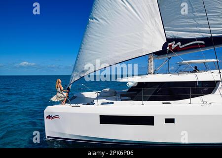 Femme appréciant le trajet sur un catamaran à voile, Exuma Cays, Bahamas Banque D'Images