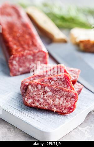 Saucisse fumée. Tranché de salami sur la planche à découper. Banque D'Images