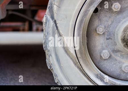 Gros plan sur le flanc du pneu endommagé, dommages causés aux pneus de la voiture dans la cour des conteneurs Banque D'Images