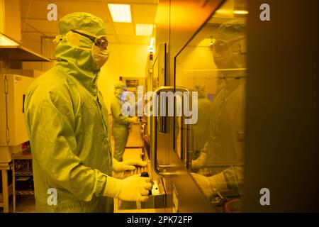 Ulm, Allemagne. 04th avril 2023. Les employés de Trumpf Photonic Components GmbH se tiennent devant les équipements de lithographie, où les wafers sont enduits et exposés sous la lumière jaune dans une salle blanche. Credit: Marijan Murat/dpa/Alamy Live News Banque D'Images