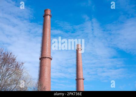 Deux grands tuyaux de cheminée industrielle abandonnés contre le ciel bleu. Cheminées une usine industrielle. Tuyaux de fumée. Tubes à fumée. Usine tuyaux tuyaux en briques. Banque D'Images