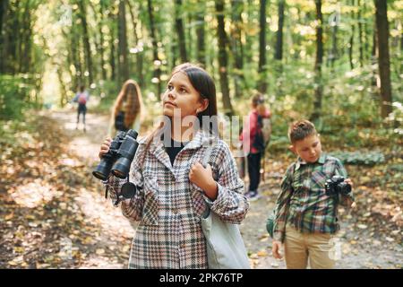 Découvrir de nouveaux lieux. Enfants dans la forêt verte pendant la journée d'été ensemble Banque D'Images